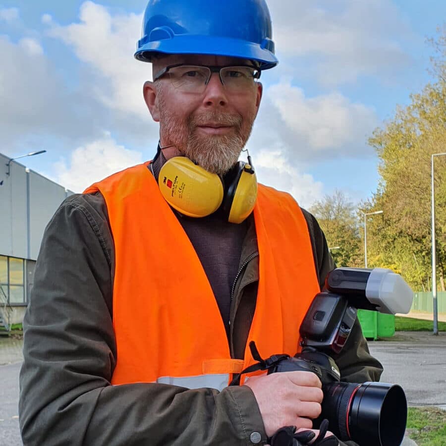Ted Walker met helm, gehoorbescherming en veiligheidshesje op locatie